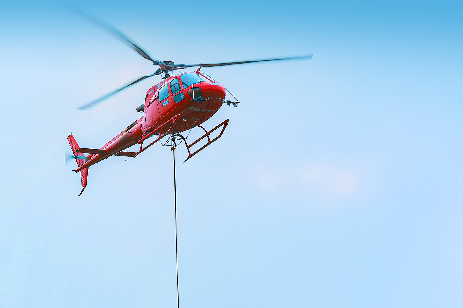 Helicóptero vermelho em operação aérea